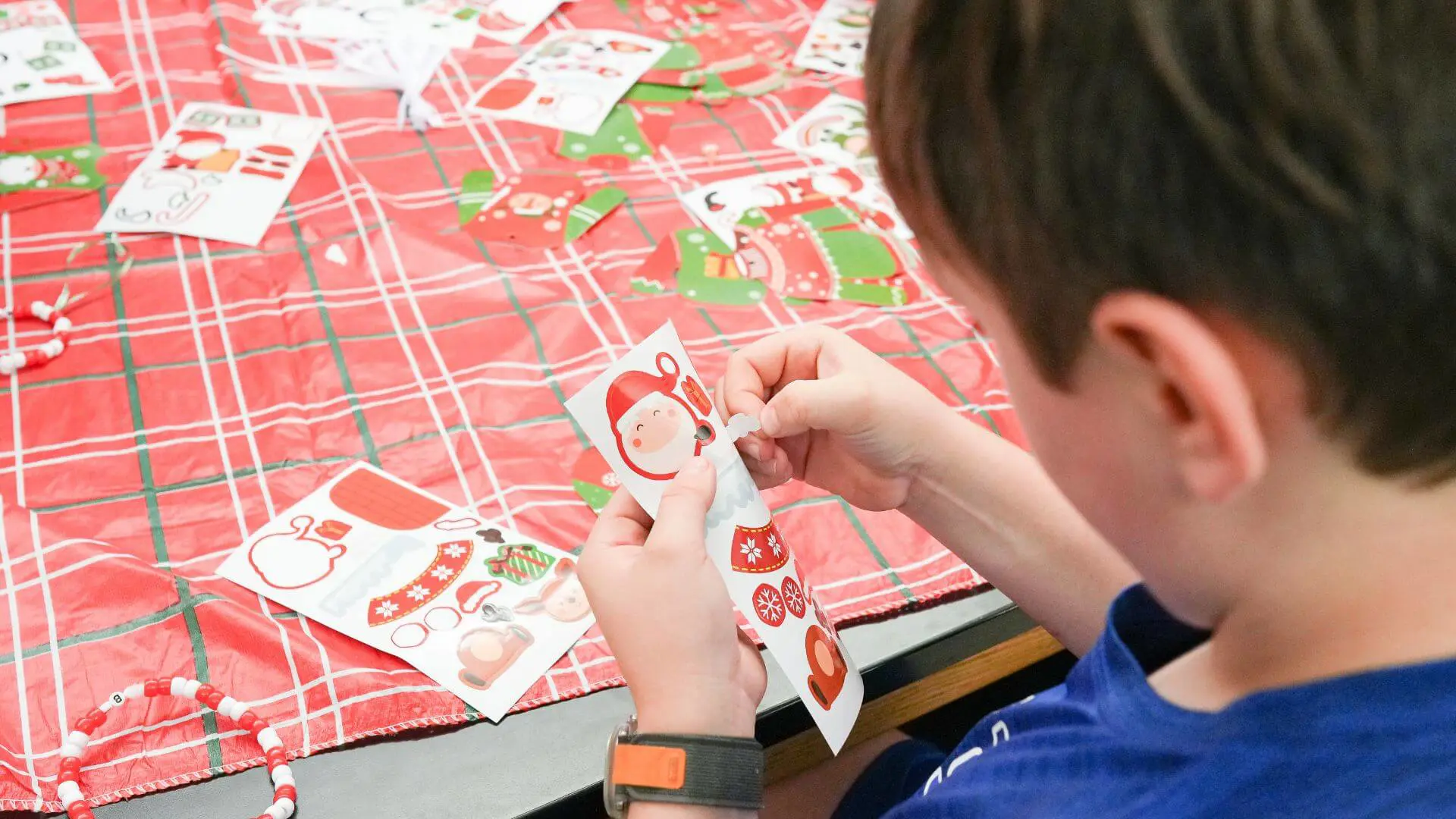 Child creating a paper Santa Claus 